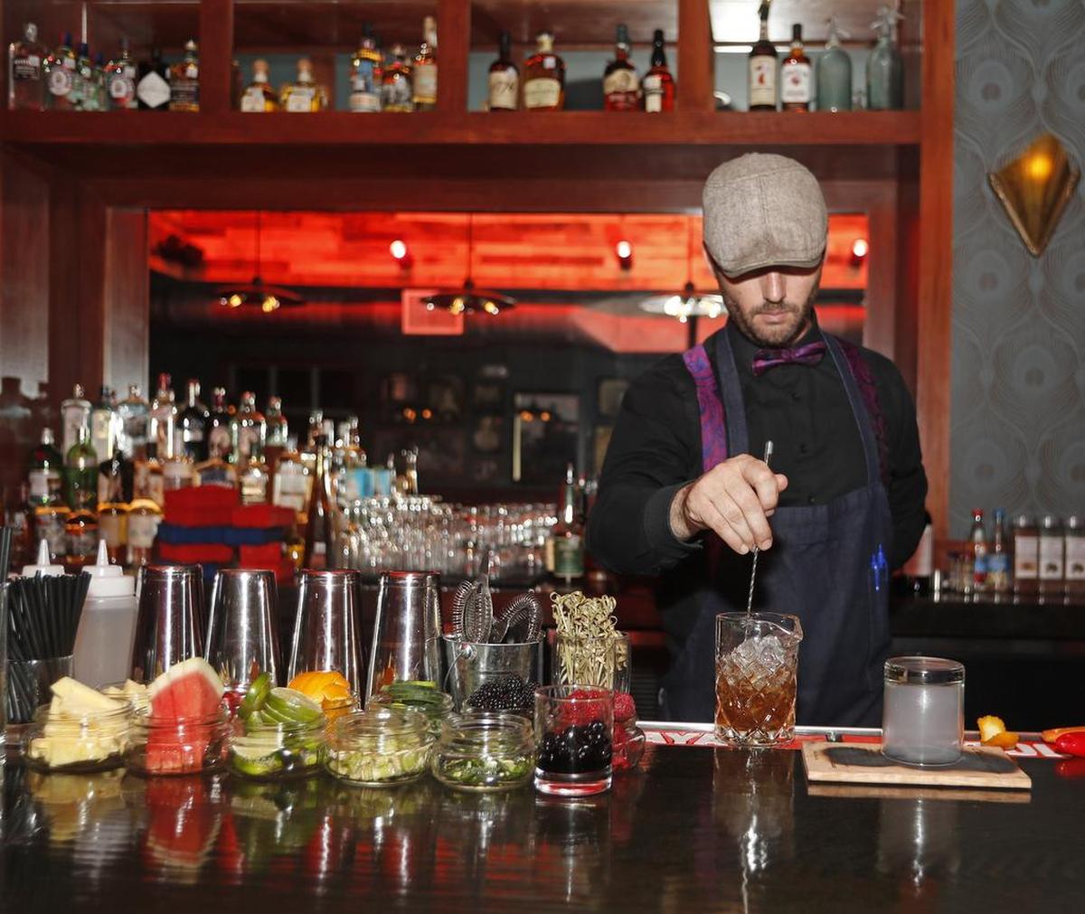 Bartender Tyson Sparks prepares a smoky drink resembling an old fashioned called “I Do What I Want” at Prohibition Chicken in Lewisville.