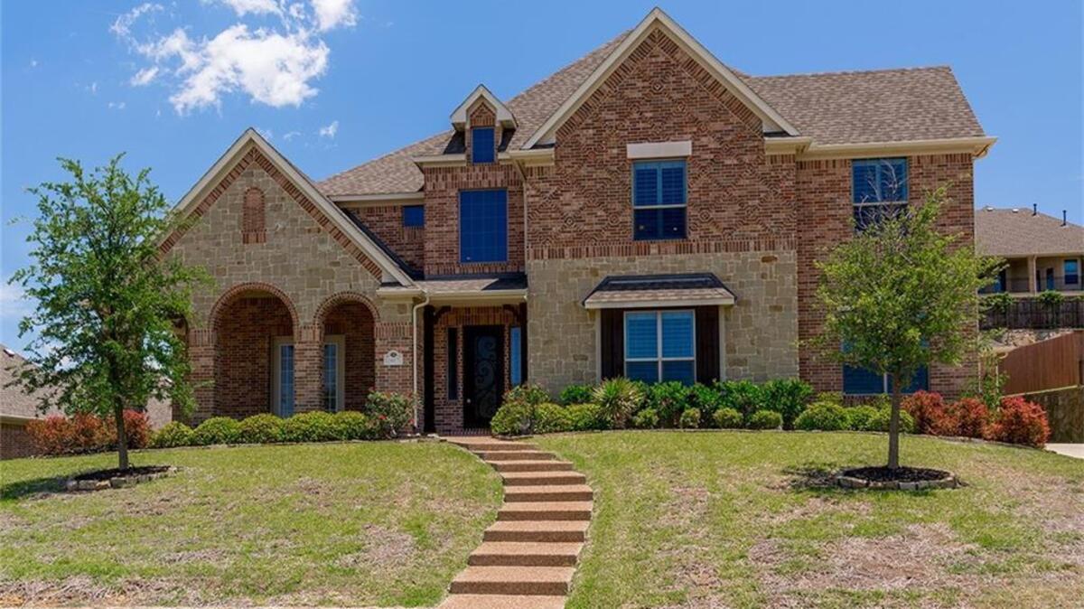 The home at 1617 Emerald Knoll Court is enhanced by stone walls and features.