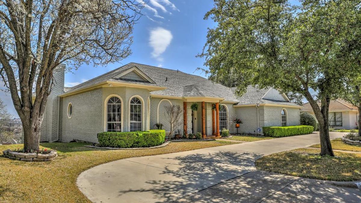 The home at 4429 Cumberland Road North features lush landscaping, mature shade trees, and a long circular drive.