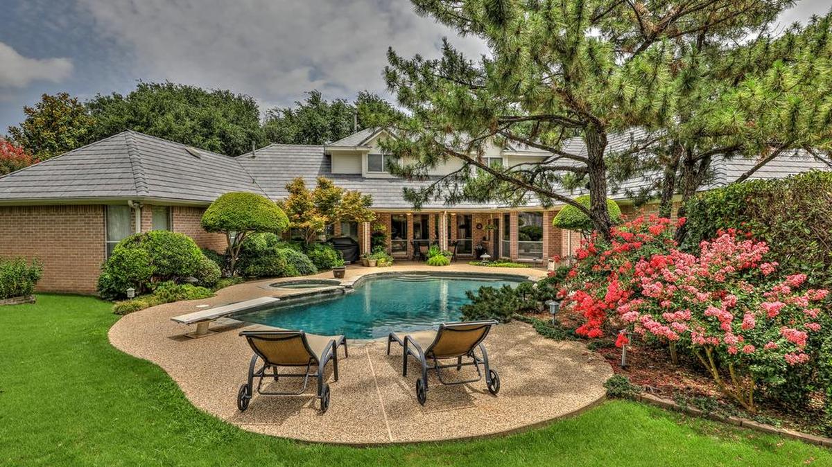 The home at 6108 Annandale Drive is located on a cul-de-sac with manicured landscaping and towering trees.