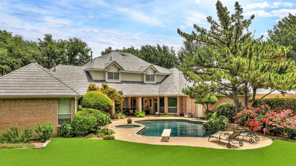 The home at 6108 Annandale Drive is located on a cul-de-sac with manicured landscaping and towering trees.