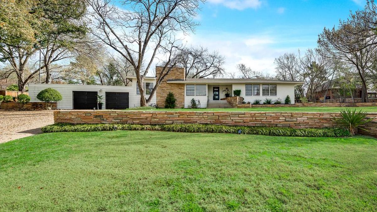 The home at 3640 Encanto Drive is situated on nearly an acre among expansive landscaping, green grasses and mature trees.