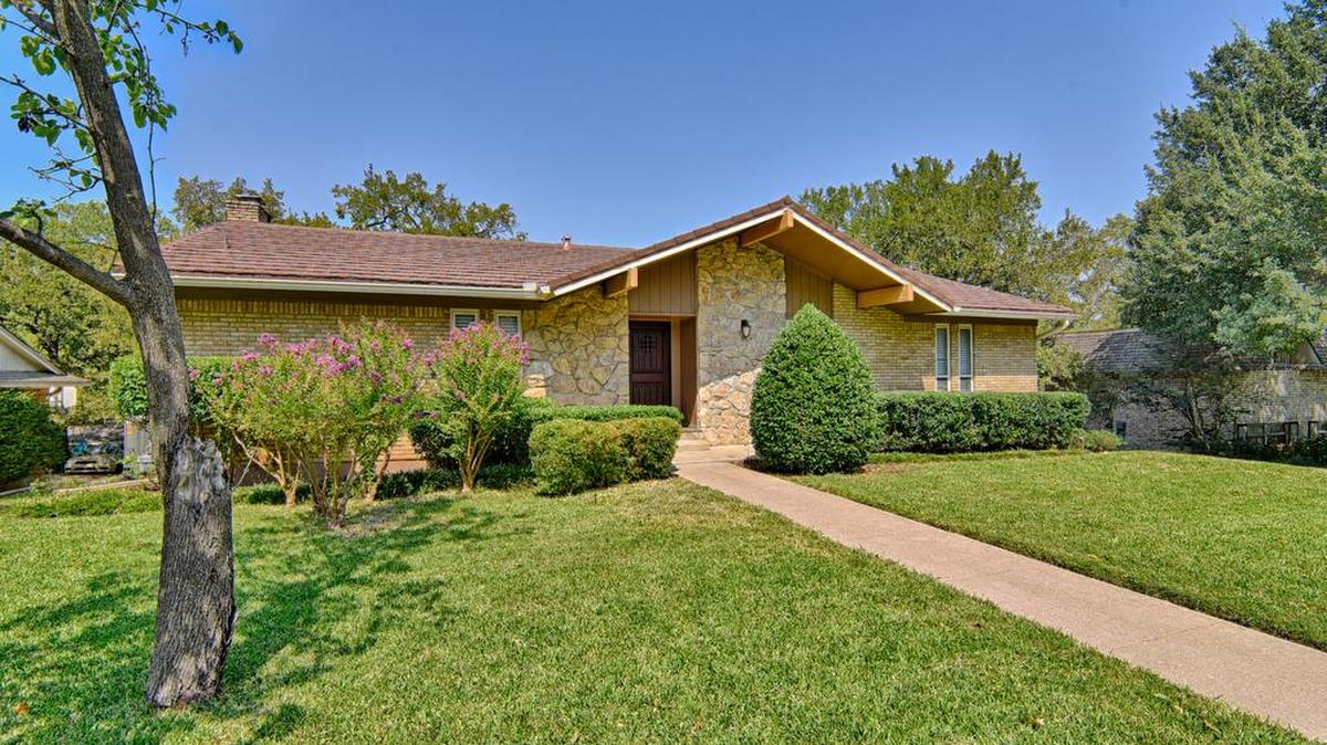 The home at 1705 Spring Lake Drive has lush green grass and manicured shrubs.