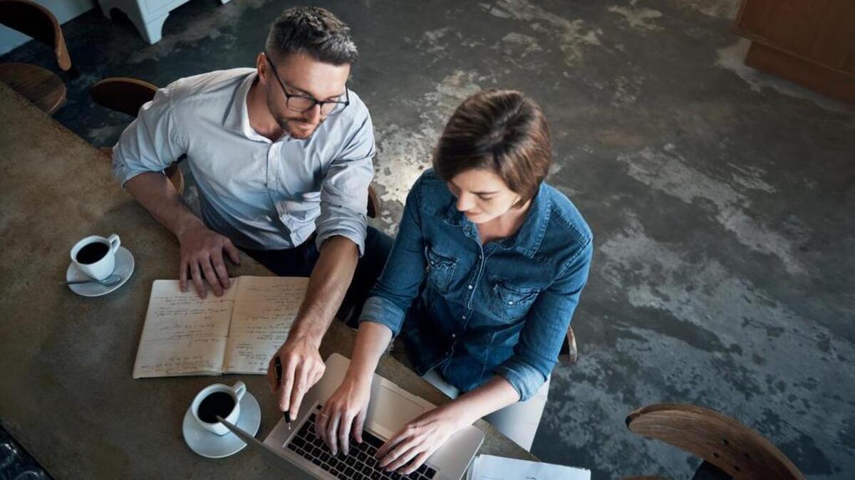High angle shot of two businesspeople working at the bar in a cafe