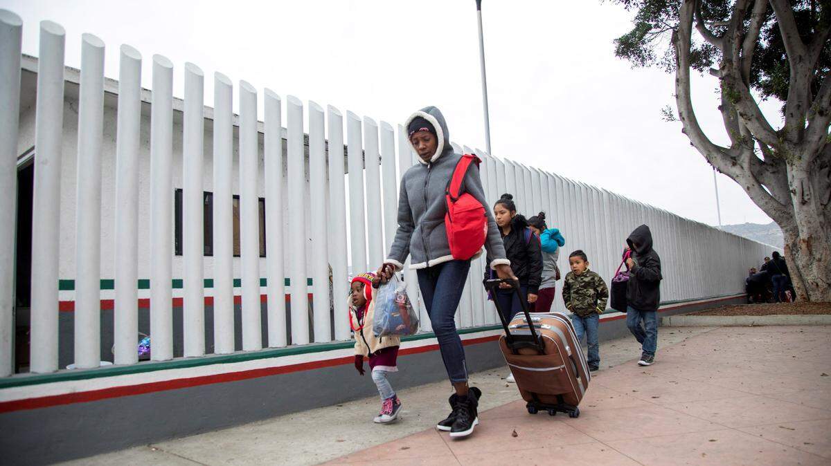Un grupo de migrantes llega para solicitar la visa humanitaria a la oficina fronteriza estadounidense de El Chaparral, en la frontera con la ciudad de Tijuana.