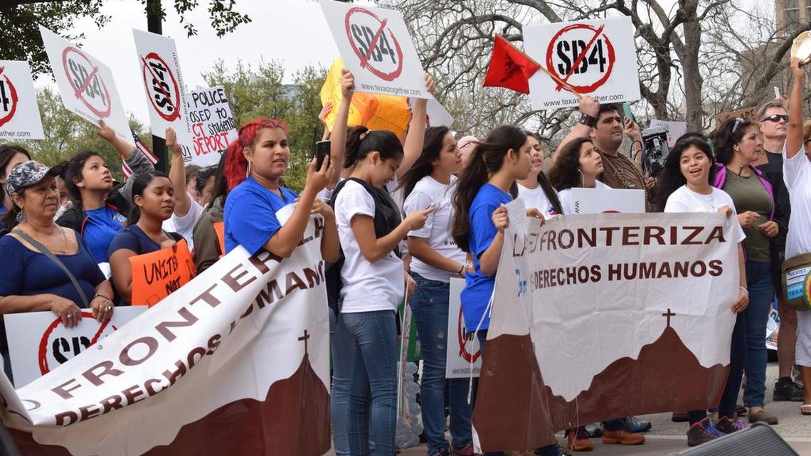 Un grupo de manifestantes sujetan pancartas en protesta por la ley SB4 en Austin.