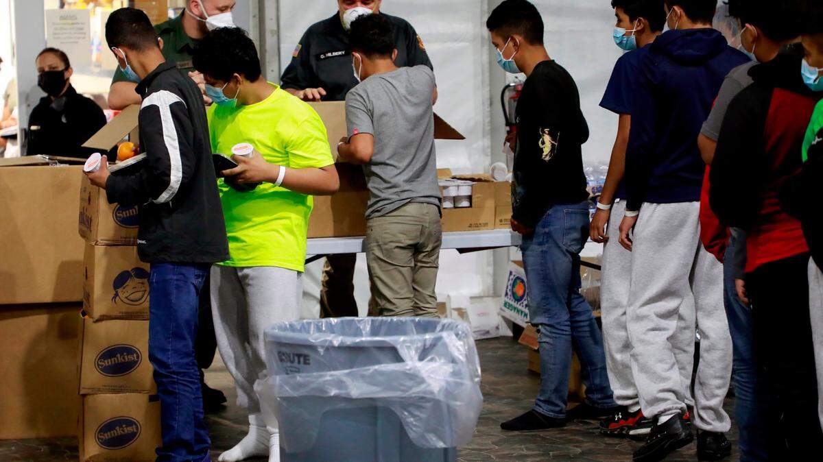 Personal de la Oficina de Aduanas y Protección Fronteriza de los EE. UU. procesa a las familias y los niños extranjeros no acompañados (UAC), bajo la custodia de la Patrulla Fronteriza, en la instalación de procesamiento temporal, en Donna, Texas.