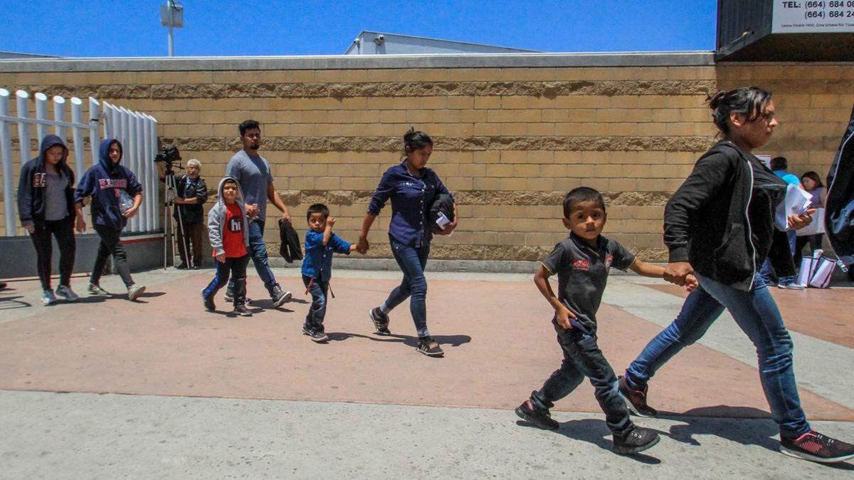 Un grupo de migrantes centroamericanos caminan ccon sus hijos en Tijuana, México.