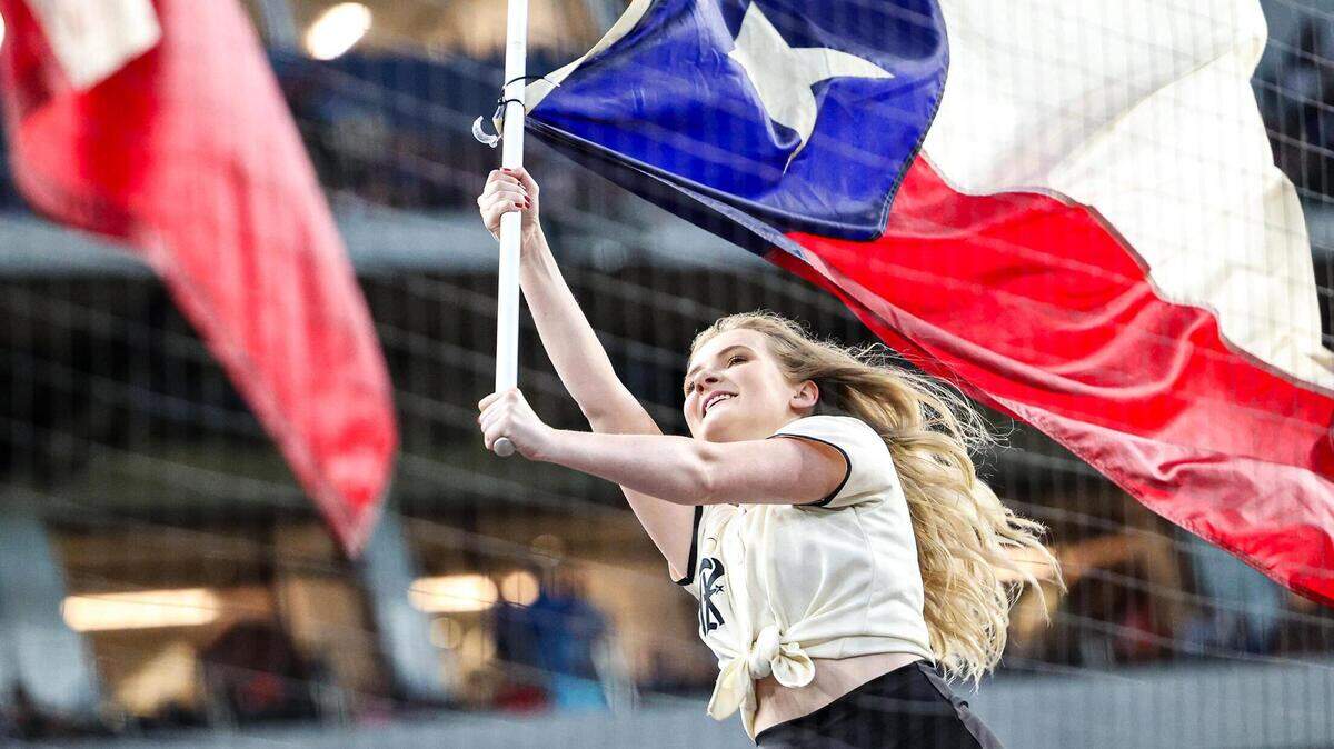 A member of the Texas Rangers Six Shooters team waves the Texas flag during the starting line up introductions of a regular season match up against the Los Angeles Dodgers at Globe Life Field in Arlington, Texas on Saturday, July 22, 2023.