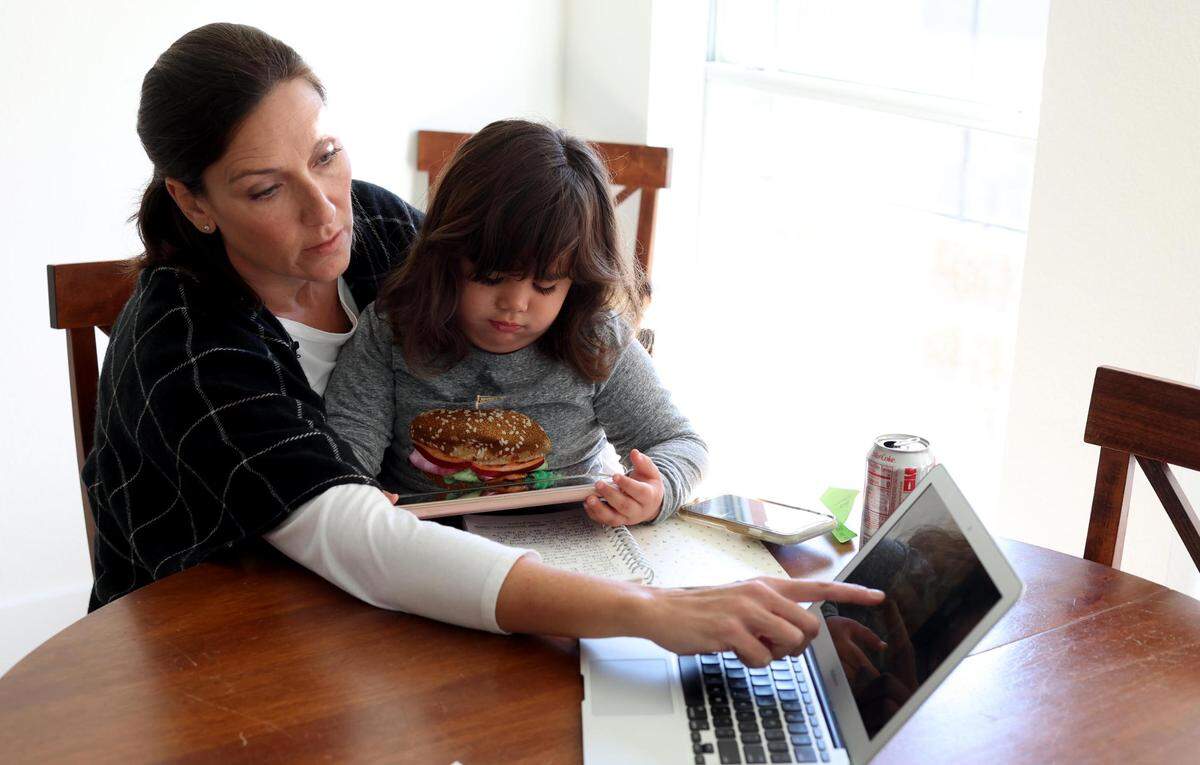 Amy Hencken shows photos of mold in her family’s home following flood damage from a burst pipe during February’s winter storm.