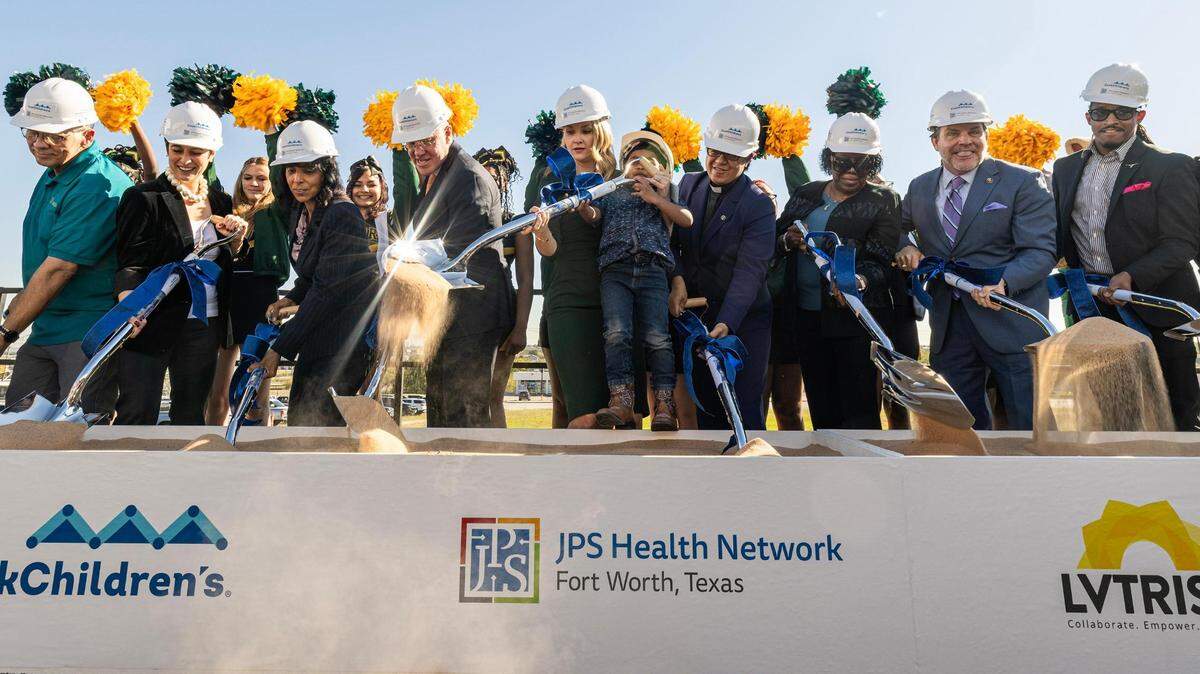 Multiple city officials and dignitaries including Paige Charbonnet, the Executive Director of the nonprofit LVTRise, Karen Duncan, the President of the JPS Health Network, Rick Merrill, the President of Cook Children’s Health Care System, Mattie Parker, the Mayor of the City of Fort Worth, while she holds Western Hills Pre-K student Darius Cotter, 4, and Michael Crain, a Councilmember for the City of Fort Worth join in participating in the groundbreaking ceremony for the Las Vegas Trail Neighborhood Health Center in Fort Worth on Tuesday, Nov. 14, 2023.