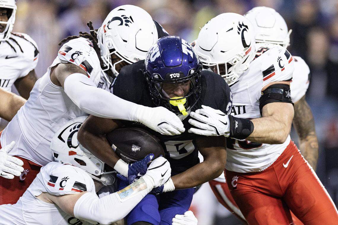 TCU running back Jeremy Payne (26) is tackled by multiple Cincinnati defenders in the first half of a Big XII conference game between the TCU Horned Frogs and the Cincinnati Bearcats at Amon G Carter Stadium in Fort Worth on Saturday, Nov. 29, 2025.