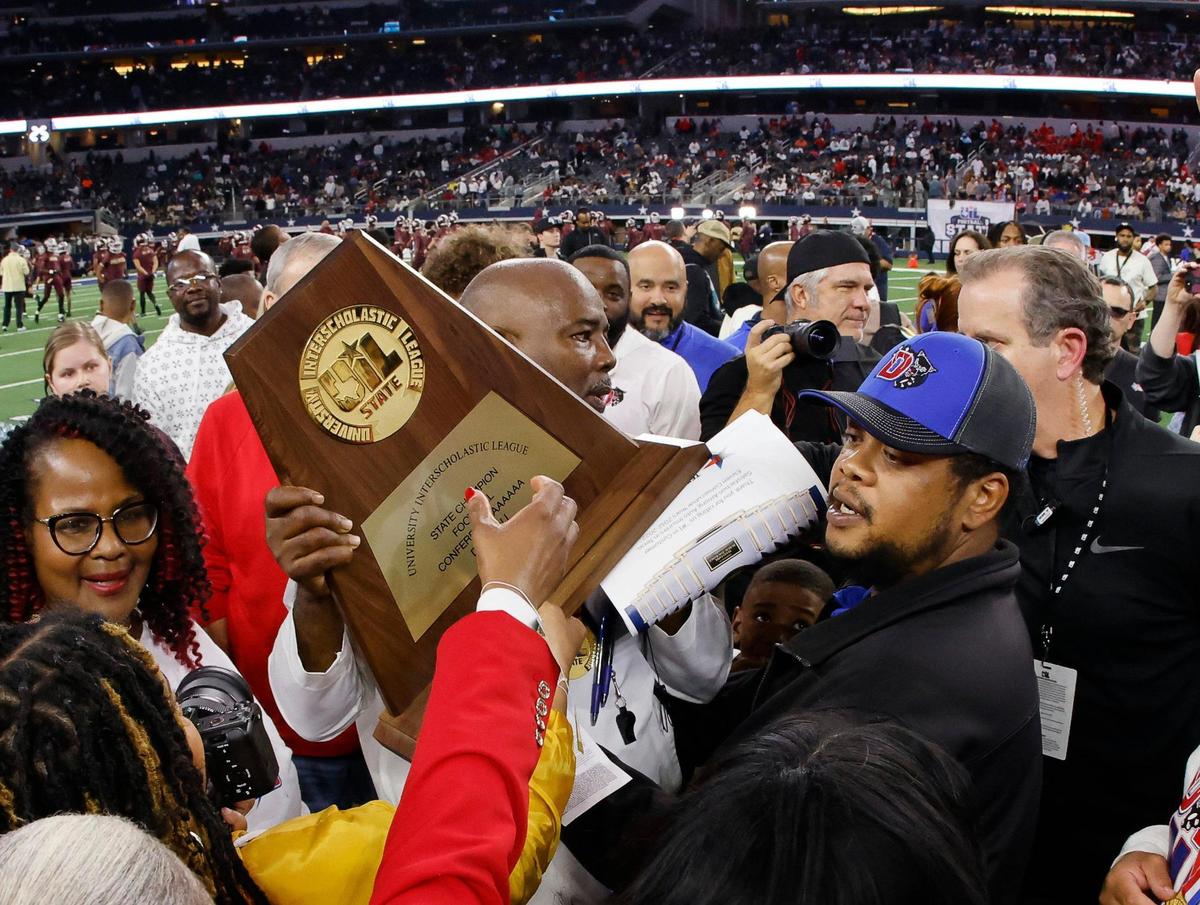 The State Championship plaque is passed into Duncanville head coach Reginald Samples after the UIL Conference 6A Division 1 state championship football game at AT&T Stadium in Arlington, Texas, Saturday, Dec. 16, 2023.