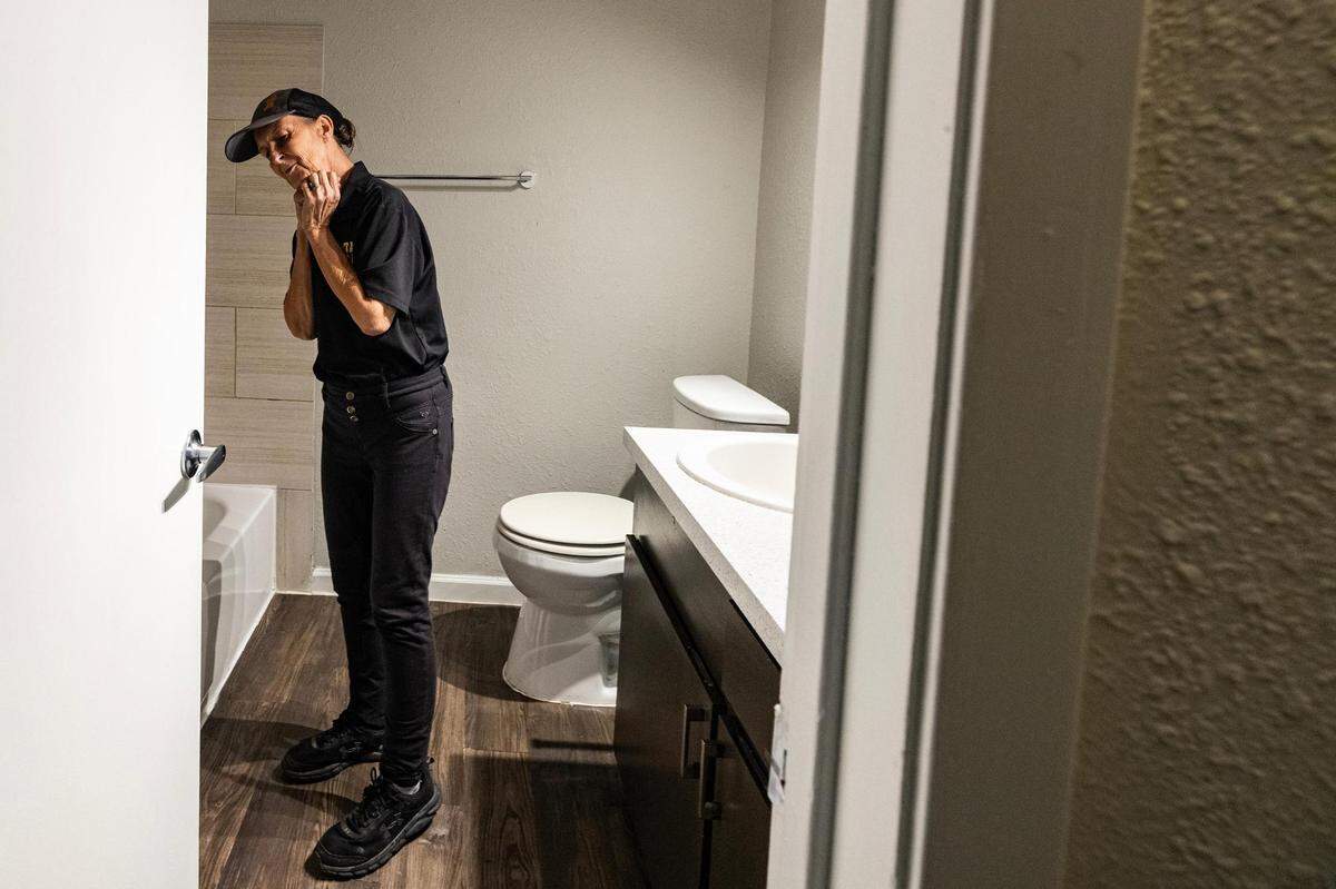 Carol Rogers reacts to seeing the bathroom with a shower at their new apartment in Saginaw on Tuesday, Nov. 21, 2023.