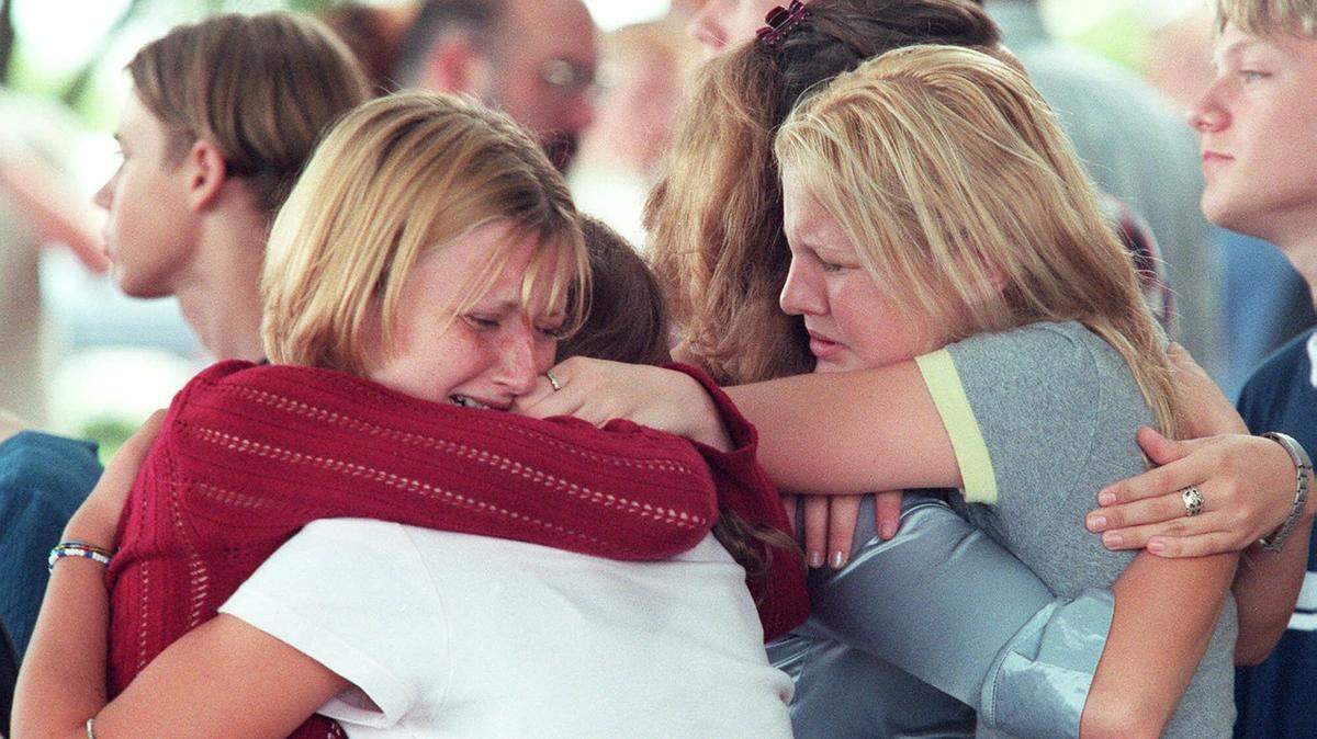 Katy Baker, left, and Jennifer Simmons, right, both 14-year-old freshmen at Brewer High School in White Settlement, Texas, hug friends as they gather Thursday, Sept. 16, 1999, at First Baptist Church of White Settlement, to mourn the death of their friend and classmate Joseph Ennis. Ennis died when a gunman opened fire in the Wedgwood Baptist Church in Fort Worth, killing seven and injuring several others, before turning the gun on himself, authorities said.