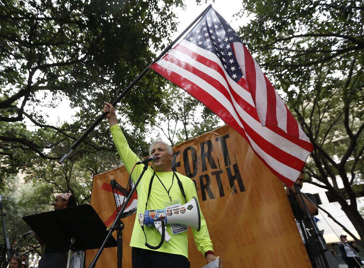 Benny Delavega waves an American Flag as he speaks at the No Kings protest in Burk Burnett Park, Fort Worth on Saturday, Oct. 18, 2025.