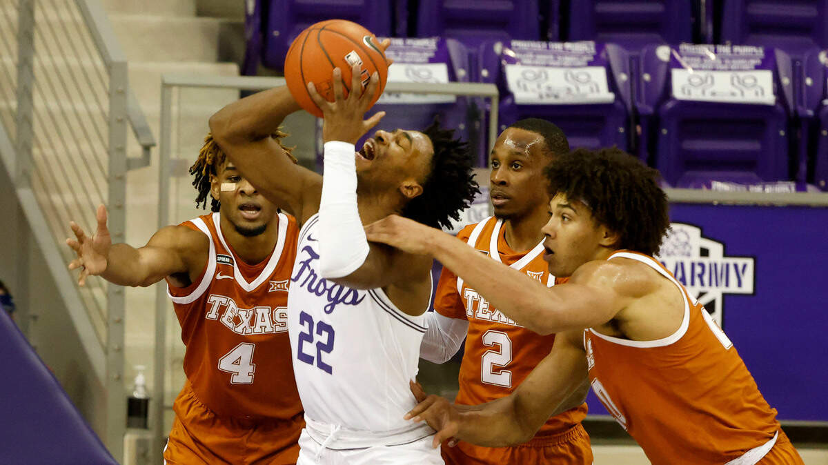 Texas forward Jericho Sims, right, fouls TCU guard RJ Nembhard (22) as Texas forward Greg Brown (4) and guard Matt Coleman III (2) defend during the first half of Sunday’s game in Fort Worth.