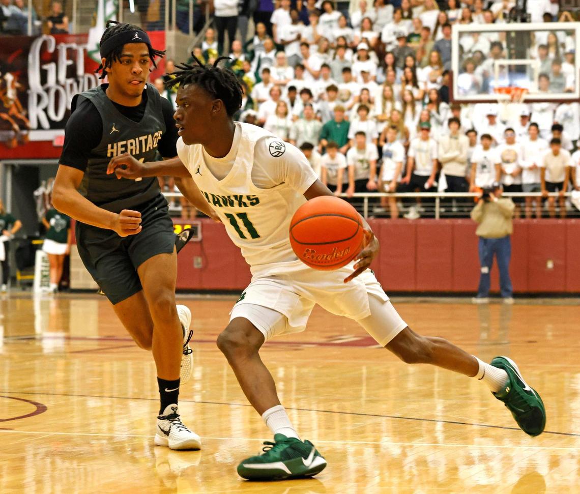Birdville guard DJ Driver (11) rounds the corner in front of Frisco Heritage point guard Garrett Shelton (1) during the first half of the UIL 5A state semifinal playoff basketball playoff game at Lewisville High School in Lewisville Texas, Tuesday, Mar. 04, 2025.