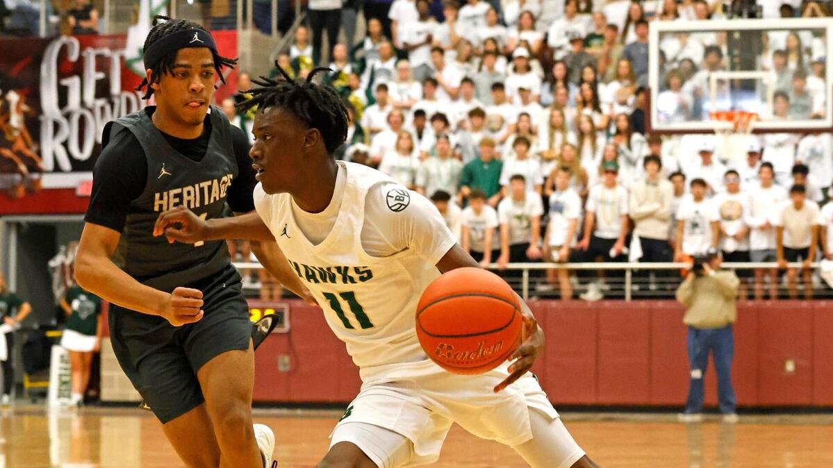 Birdville guard DJ Driver (11) rounds the corner in front of Frisco Heritage point guard Garrett Shelton (1) during the first half of the UIL 5A state semifinal playoff basketball playoff game at Lewisville High School in Lewisville Texas, Tuesday, Mar. 04, 2025.