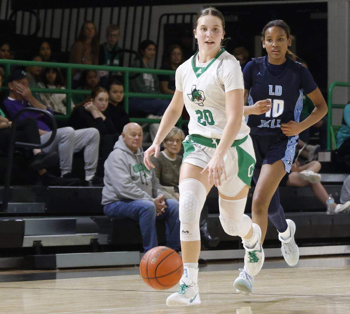 Southlake guard Whitney Jense (20) brings the ball down court in front of L.D. Bell guard Maddison Rhodes (10) during the second half of a UIL girls basketball game between L.D. Bell and Southlake Carroll at Southlake Senior High School in Southlake, Texas, Tuesday Feb. 03, 2026