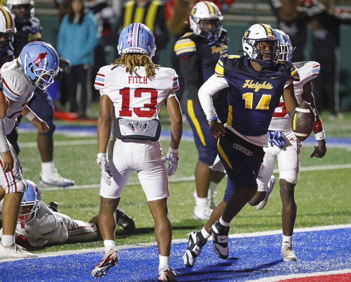 Fort Worth Arlington Heights quarterback Carmelo Carter (14) scores one of his three touchdowns during the first half of a UIL Class 5A DI area-round football playoff game Thursday Nov. 20, 2025 at Shotwell Stadium in Abilene, Texas.