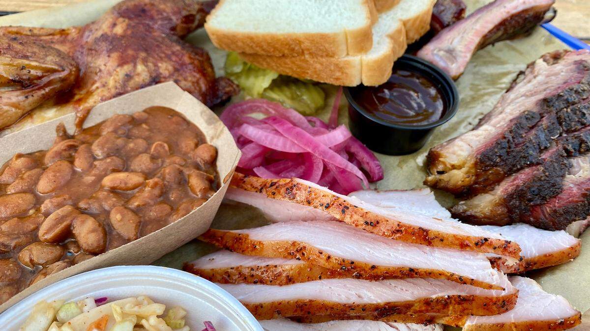 A Rack Attack BBQ platter with turkey, brisket, pork ribs, chicken, chipotle slaw and beans.
