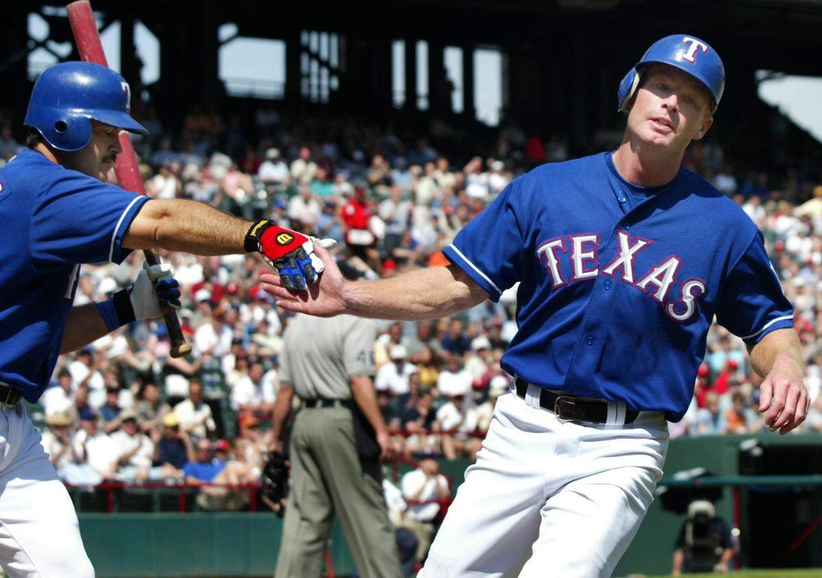Rangers Rusty Greer (right) is congratulated by Rafael Palmeiro (left) after Greer scored in the 4th inning of the Texas Rangers vs the Oakland A's game at the Ballpark in Arlington, Thursday, March 11, 2002, in Arlington,Texas.  (Star-Telegram/Ron Jenkins)
