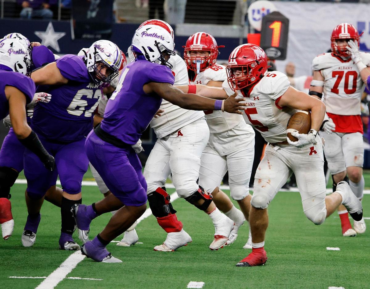Albany running back Adam Hill stiff arms Mart defensive back De’Montrel Medlock in the backfield during the second half of the UIL Conference 2A Division 2 state championship football game at AT&T Stadium in Arlington, Texas, Thursday, Dec. 14, 2023.