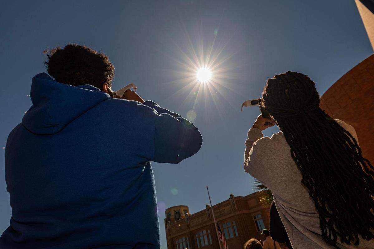 Siblings Adam and Bethany Davis look up at the solar eclipse during the Annular Solar Eclipse event at the Fort Worth Museum of Science & History on Saturday, Oct. 14, 2023.
