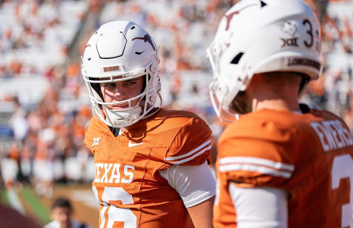 Texas quarterbacks Arch Manning (16) and Quinn Ewers talk prior to a game in the 2023 season.