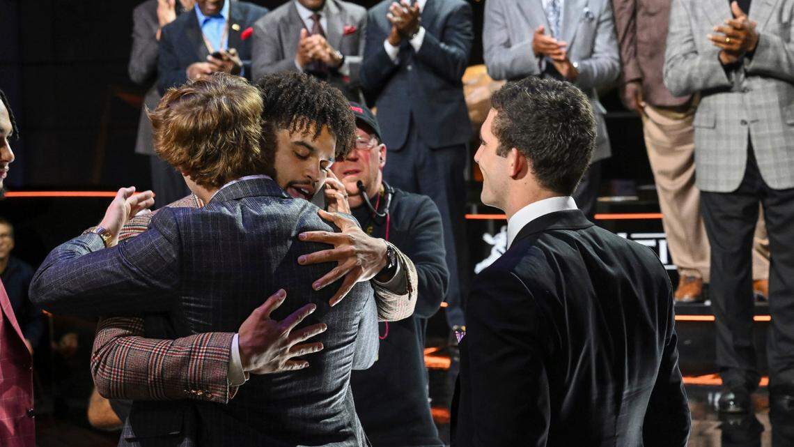 TCU quarterback Max Duggan, back to camera, hugs Southern California quarterback Caleb Williams hugs after Williams won the Heisman Trophy on Saturday, in New York. At right front is Georgia quarterback Stetson Bennett.