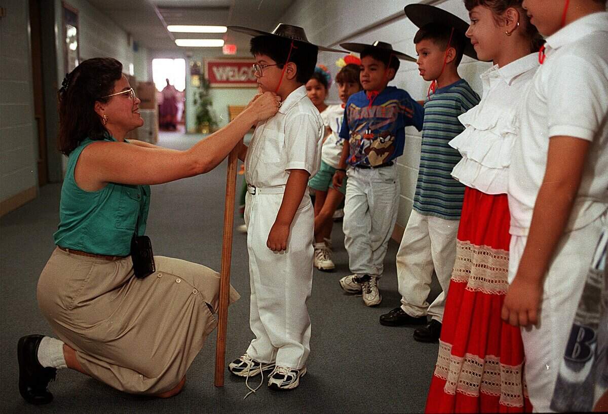Sept. 16, 1998: Norma Atkinson, first-grade teacher at Berry Elementary School in Arlington, ties a Mexican hat on the head of Felix Resendiz, 6, before the class goes to assembly. The school celebrated Mexican Independence Day with costumes and dances.