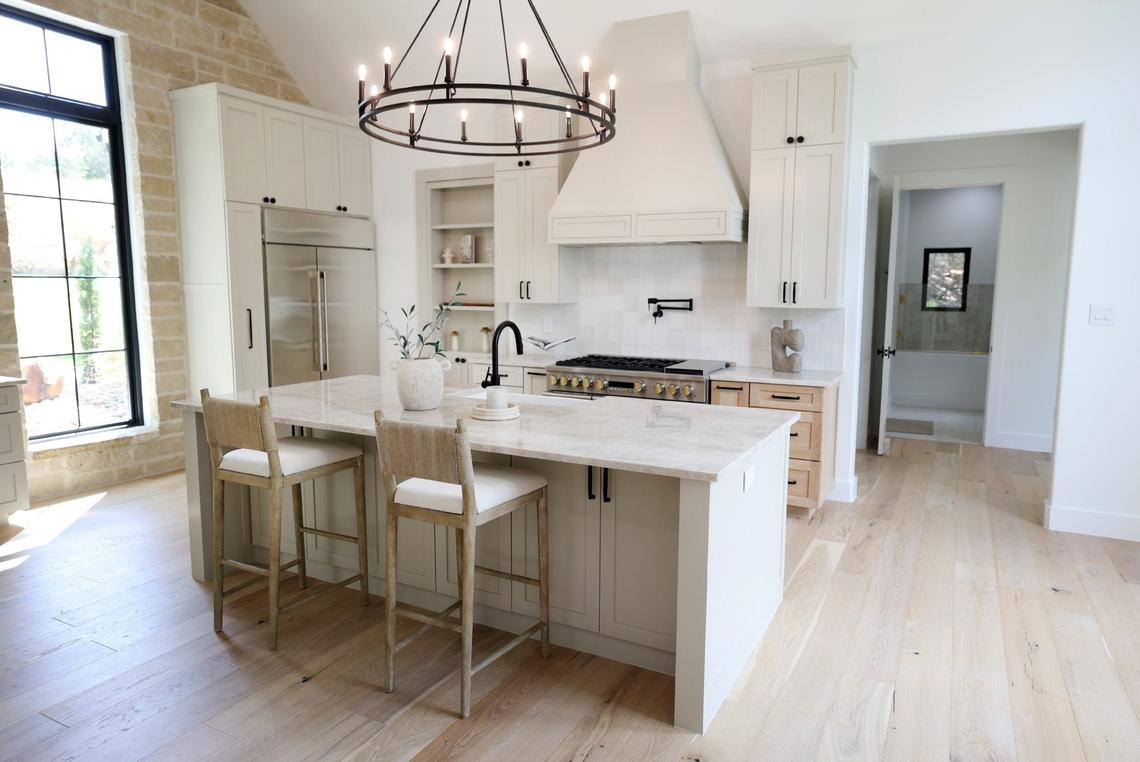 The kitchen of a $2 million dollar new build in the Silverado on the Brazos community outside of Weatherford includes a hidden butler’s pantry and Taj Mahal quartzite countertops.