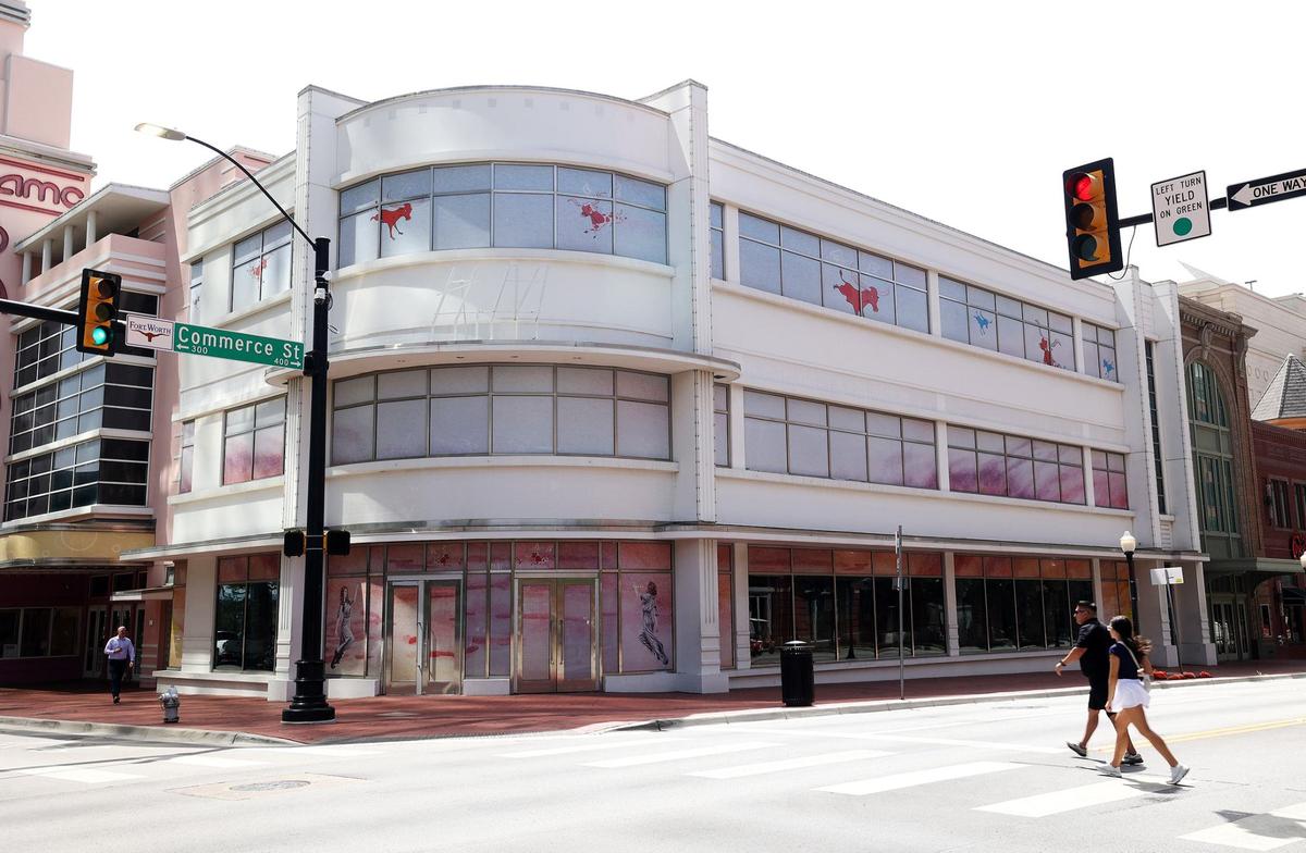 Artwork covers the windows of an empty building at the corner of Commerce Street and East Third Street.