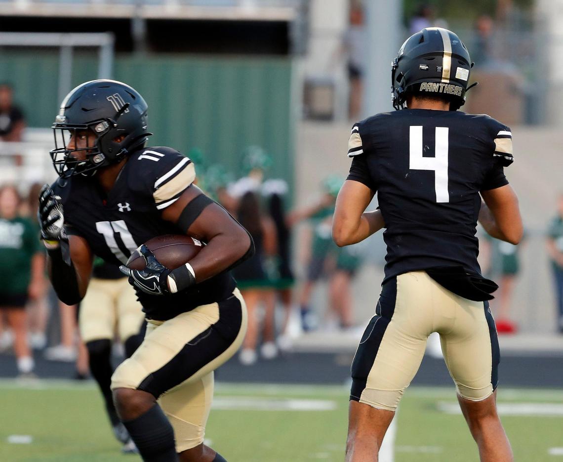 Fossil Ridge running back Landen Chambers (11) takes the hand off from quarterback Logan Cundiff (4) in the first half of a high school football game at Keller ISD Stadium in Keller, Texas, Thursday, Sept. 08, 2022. Keller Fossil Ridge led 20-14 over Arlington High School at the half. (Special to the Star-Telegram Bob Booth)