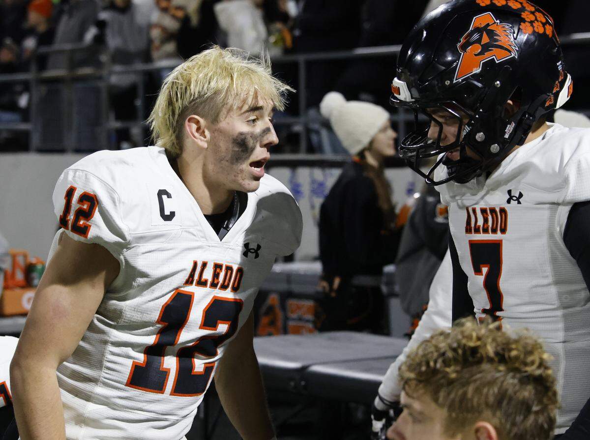 Aledo quarterback Lincoln Tubbs (12) talks with quarterback Christian Sandoval (7) on the bench during the second half of a UIL Class 5A Division I Quarterfinal on Friday Dec. 05, 2025 at Northwest ISD Stadium in Fort Worth, Texas.