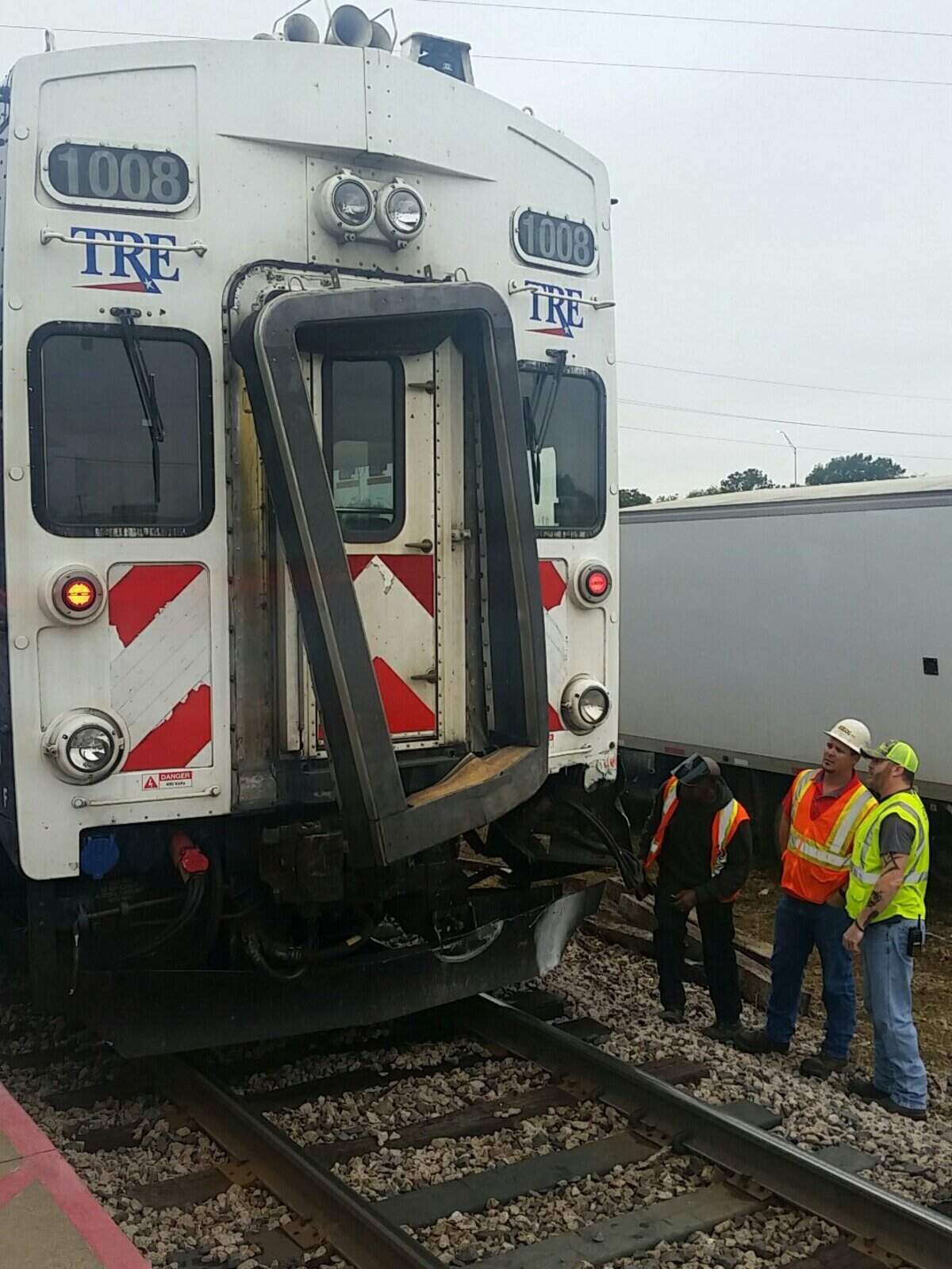 Workers inspect the damage after a TRE train collided with a flatbed trailer Wednesday morning.