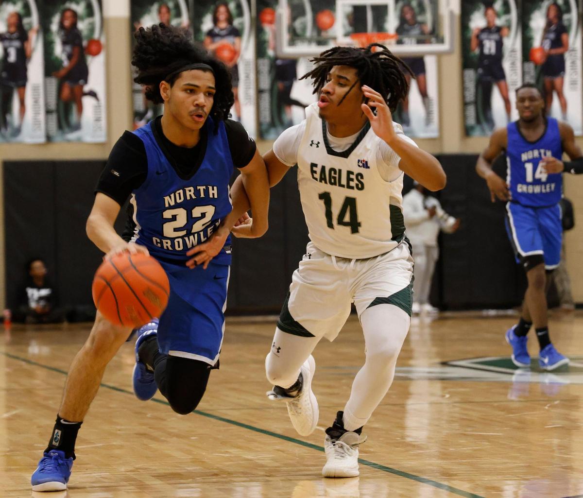 North Crowley guard Isaak Hayes (22) drives hard against Lake Ridge guard Deshawn Edwards (14)during a UIL boys basketball game at Lake Ridge High School in Mansfield, Texas, Friday, Jan. 24, 2025.