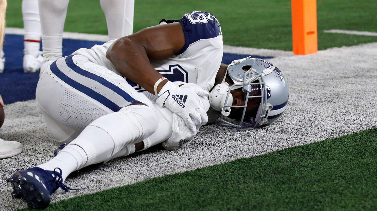 Dallas Cowboys wide receiver Michael Gallup holds his left knee after catching a touchdown late in the first half Sunday. After the game, team owner Jerry Jones said Gallup had torn his ACL.