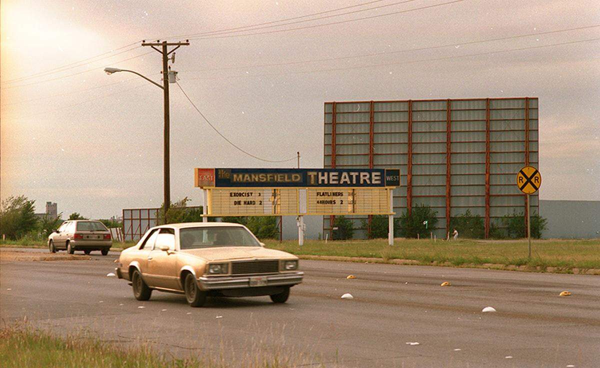 Sept. 30, 1990: Mansfield Drive-in on East Seminary Drive, Fort Worth. There is a sign visible that reads “The Mansfield Theatre” with a list of movies underneath, including The Exorcist III, Die Hard 2, Flatliners, and Another 48 Hrs.