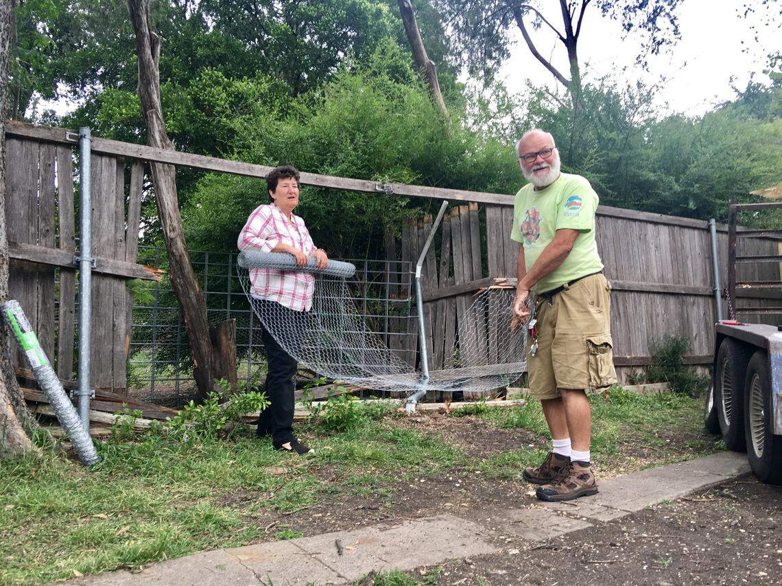 Central Christian Church members repair a fence that was damage during a high-speed police chase in Dallas on Tuesday night. The suspect Armando Jaurez was wanted for the shooting of two Dallas police officers earlier in the day.