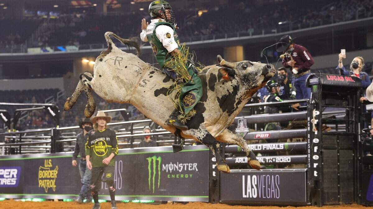 A rodeo competitor tries to stay atop a bull at the PBR World Finals in 2020 at AT&T Stadium. 