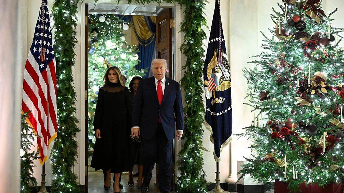WASHINGTON, DC - DECEMBER 5: President Donald Trump and first lady Melania walk among Christmas decorations en route to the East Room at the White House on December 5, 2025 in Washington, DC. Andrea Bocelli performed a concert in the East Room for the President and first lady. (Photo by John McDonnell/Getty Images)