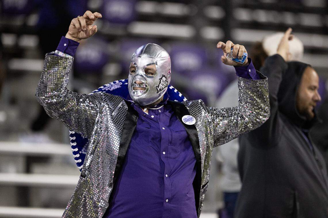 A TCU fan cheers for the Horned Frogs win a luchador wrestling mask in the second half of a Big XII conference game between the TCU Horned Frogs and the Cincinnati Bearcats at Amon G Carter Stadium in Fort Worth on Saturday, Nov. 29, 2025.