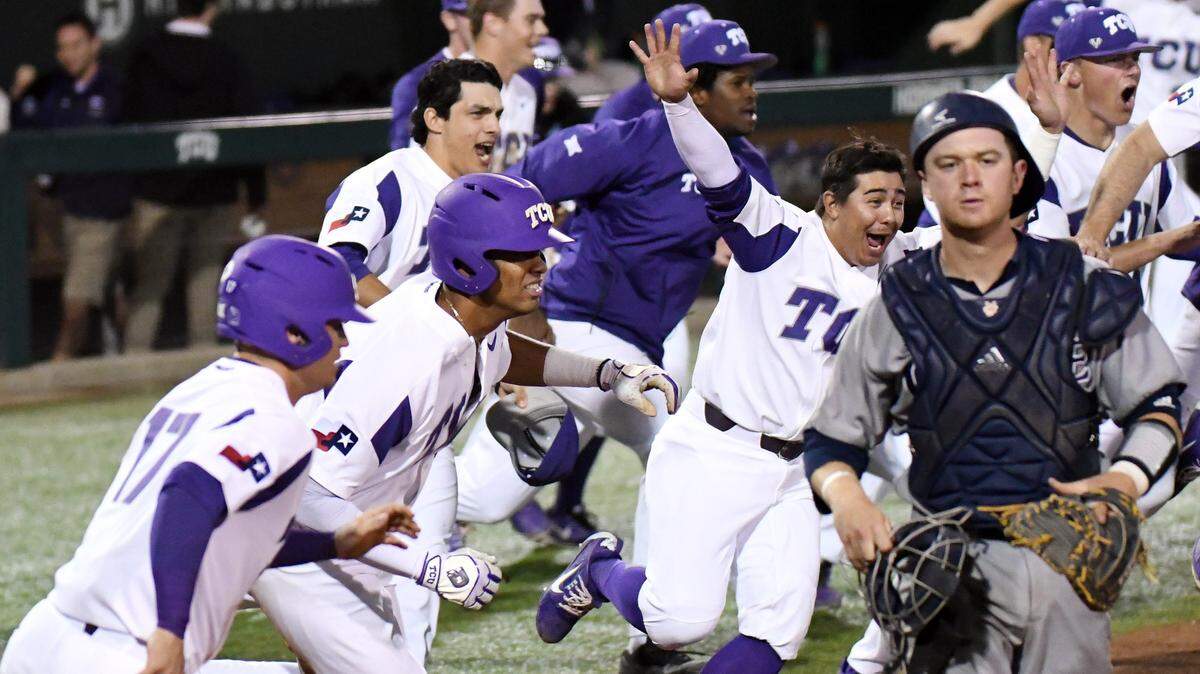 TCU players rush the field in celebration as the winning run scores in the bottom of the ninth inning Friday night against UC Irvine and catche Jacob Castro.