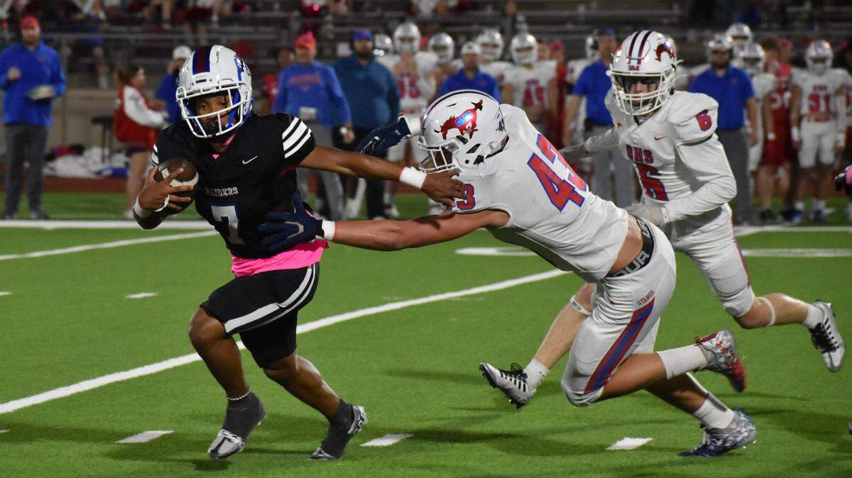 Fort Worth Southwest quarterback Jahbori Cooper-Suttice tries to escape the grasp of Grapevine’s Bradley Stanyer during Thursday’s game at Herman C. Clark Stadium.