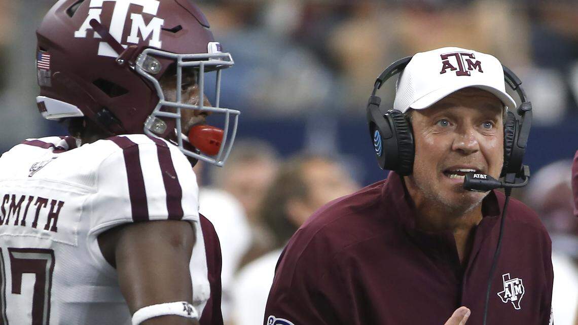 FILE - In this Sept. 28, 2019, file photo, Texas A&M head coach Jimbo Fisher talks with his team as wide receiver Ainias Smith (17) looks on as they play Arkansas during the first half of an NCAA college football game in Arlington, Texas. Texas A&M’s football program was placed on probation and Fisher given a six-month show cause order by the NCAA on Thursday, July 2, 2020, after the Aggies were found to have violated recruiting and other rules beginning in January 2018. (AP Photo/Ron Jenkins, File)