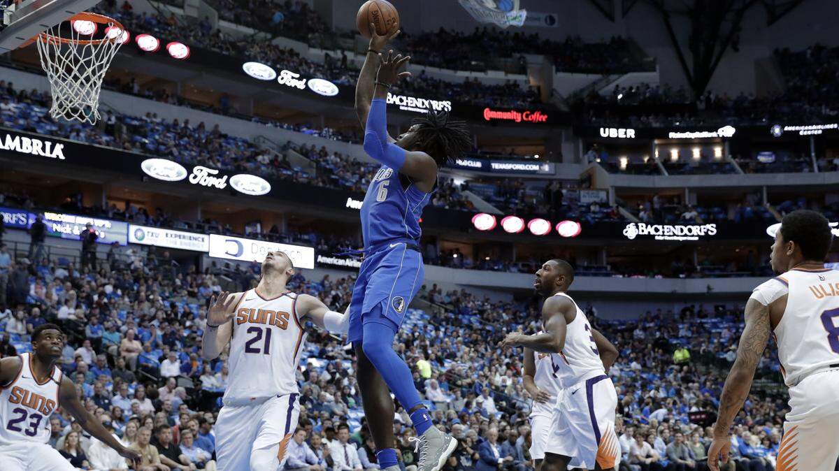 Mavericks forward Johnathan Motley (6) takes a shot as Phoenix Suns' Danuel House Jr. (23), Alex Len (21), Davon Reed, second from right, and Tyler Ulis, right, defend in the first half of Tuesday's season finale.
