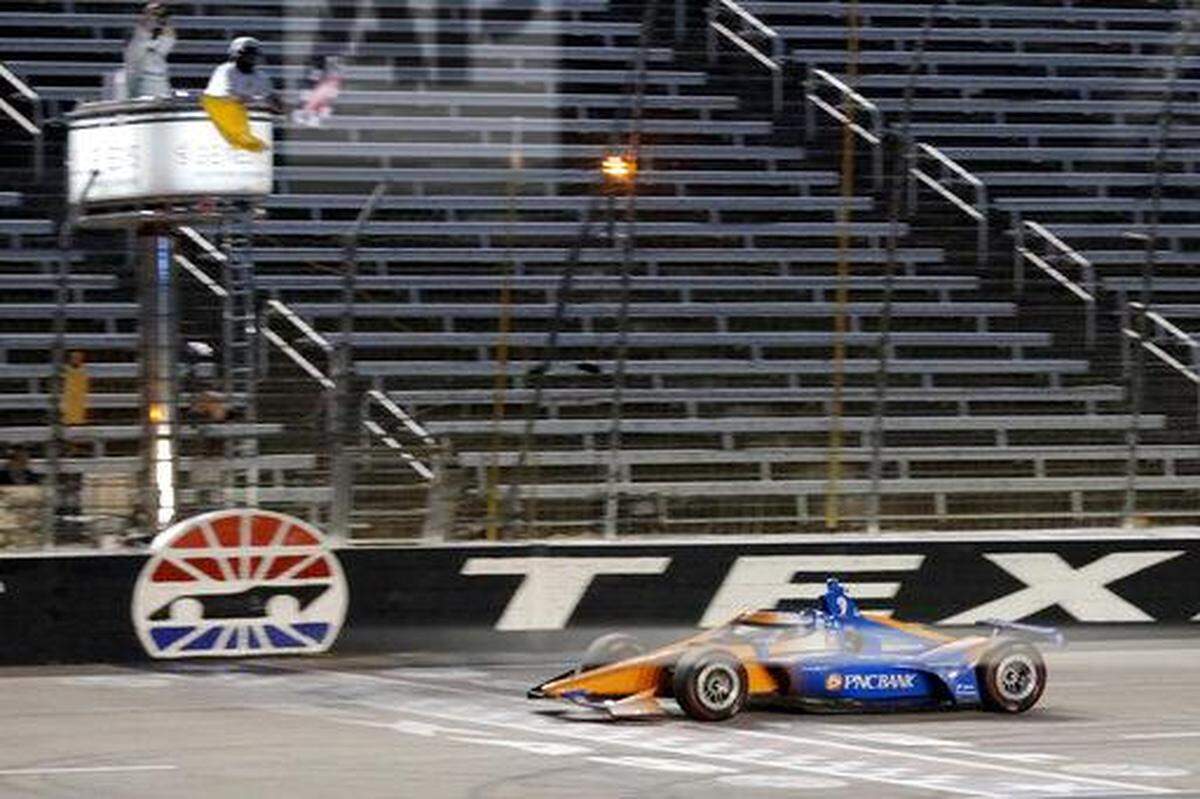 Scott Dixon earns the checkered flag as he crosses the finish line to win an IndyCar auto race at Texas Motor Speedway in Fort Worth, Texas, Saturday, June 6, 2020. (AP Photo/Tony Gutierrez)
