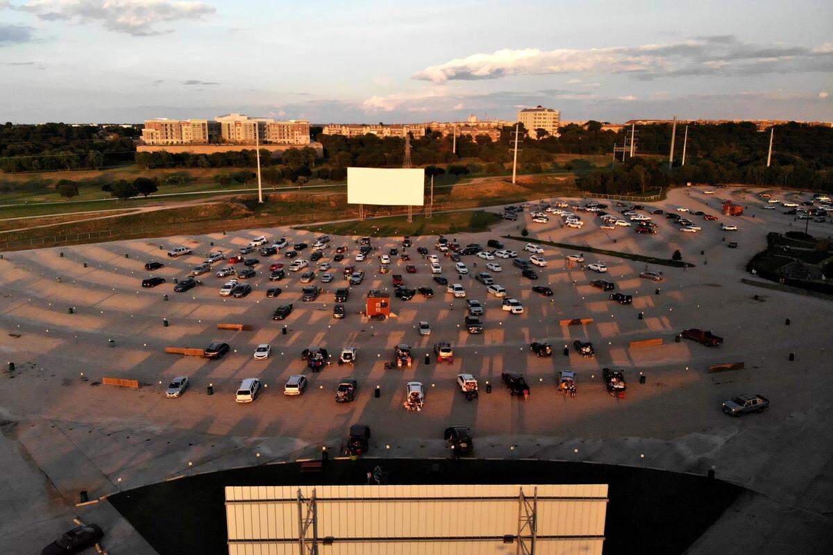 The sun sets as a movie begins at one of four screens at Coyote Drive-In movie theater on Wednesday, May 27, 2020, in Fort Worth. The drive-in initially closed during the coronavirus pandemic, but opened at limited capacity when the state began reopening in May. Chris Fortune, director of operations at the drive-in, said they have sold out every night.